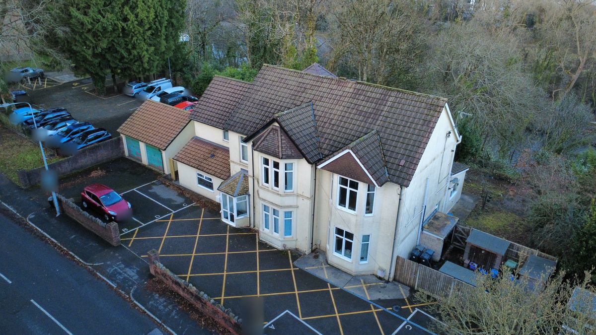Aerial photo of a cream house and its car park